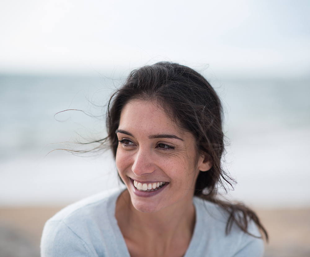 Portrait of a beautiful young brunette woman on the beach